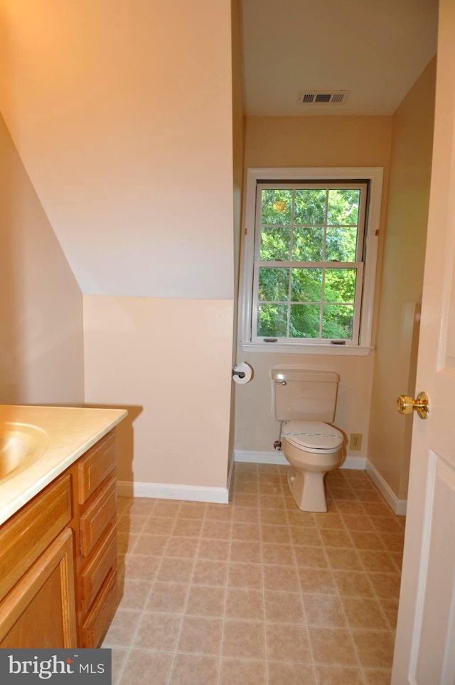 bathroom featuring toilet, vanity, and baseboards