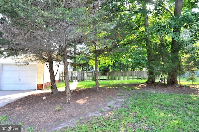 view of yard with fence and a garage