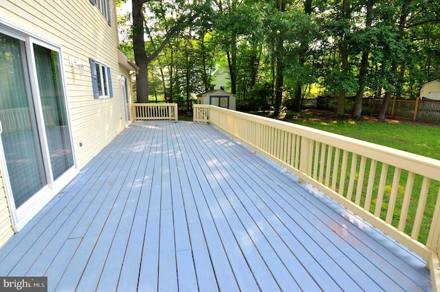 wooden deck featuring a storage unit and an outdoor structure