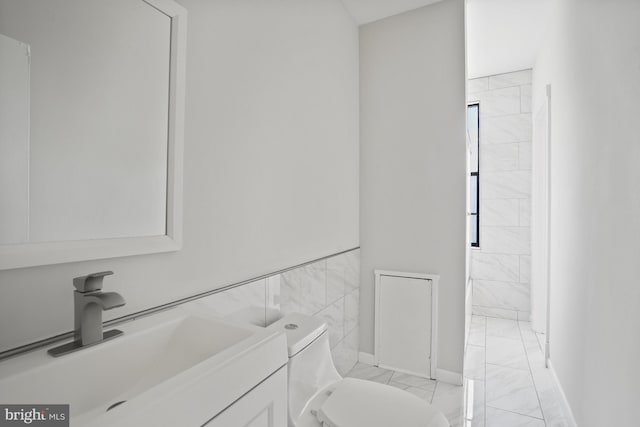 7 18th St SE Unit 208, Washington, DC 20003 - bathroom featuring marble finish flooring, vanity, toilet, and baseboards