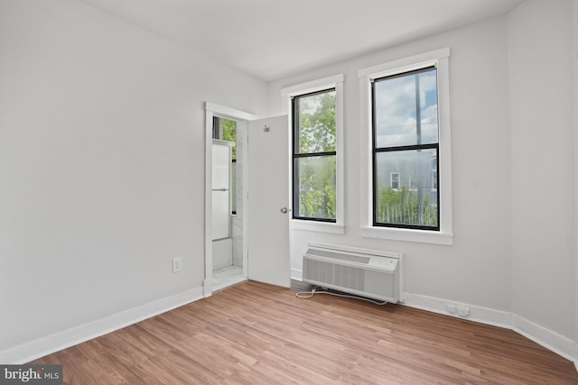 7 18th St SE Unit 208, Washington, DC 20003 - unfurnished room with light wood-style floors, baseboards, and a wall unit AC