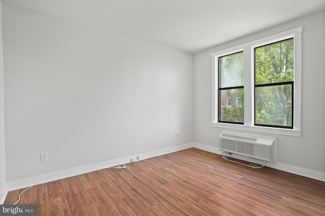 7 18th St SE Unit 208, Washington, DC 20003 - empty room featuring wood finished floors, baseboards, and a wall mounted air conditioner