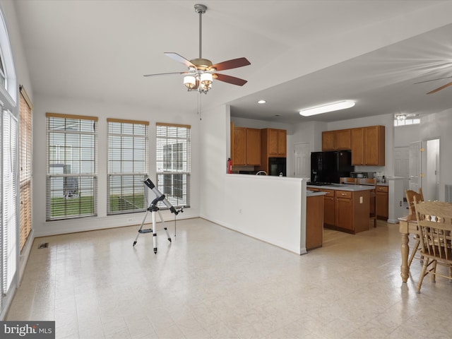 5204 Spanish Dollar Ct, Woodbridge, VA 22193 - kitchen with ceiling fan, freestanding refrigerator, brown cabinetry, lofted ceiling, and a peninsula
