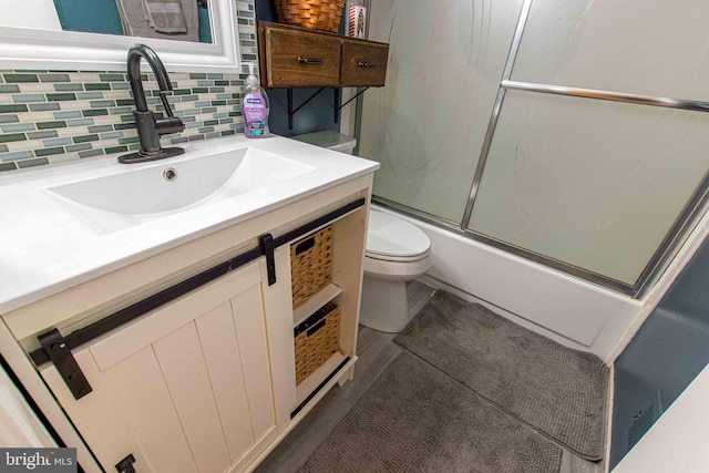 14365 Salsbury Ct, Woodbridge, VA 22193 - full bathroom with toilet, combined bath / shower with glass door, vanity, and backsplash