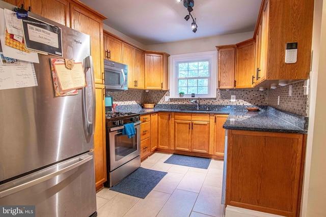 14365 Salsbury Ct, Woodbridge, VA 22193 - kitchen with appliances with stainless steel finishes, tasteful backsplash, a sink, and brown cabinetry