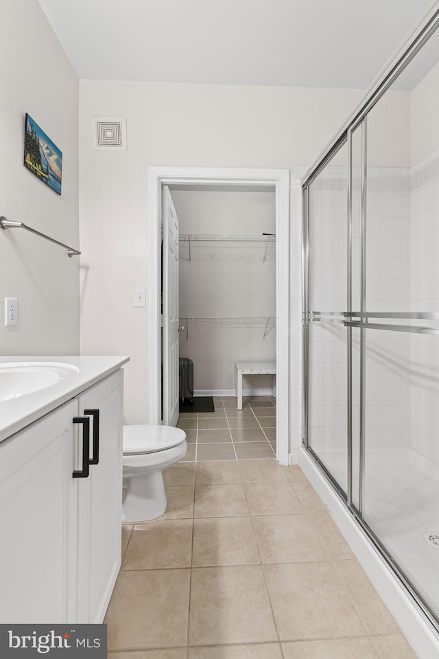 12958 Centre Park Cir Unit 219, Herndon, VA 20171 - bathroom featuring a stall shower, vanity, tile patterned floors, and a spacious closet