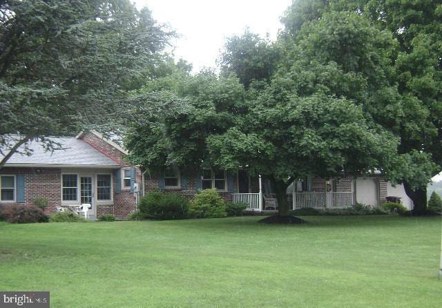 5075 E Berlin Rd, East Berlin, PA 17316 - view of front facade featuring a front lawn, brick siding, and covered porch