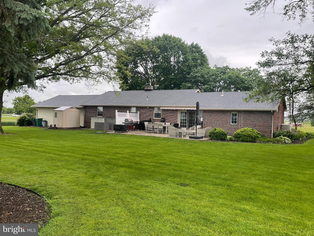 5075 E Berlin Rd, East Berlin, PA 17316 - rear view of house with brick siding, a patio, a yard, and an outdoor living space