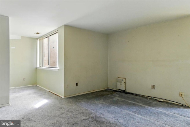 carpeted spare room featuring baseboards