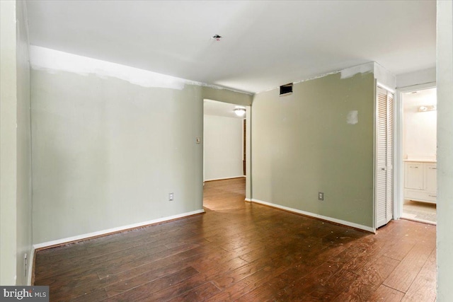 empty room with hardwood / wood-style floors and baseboards