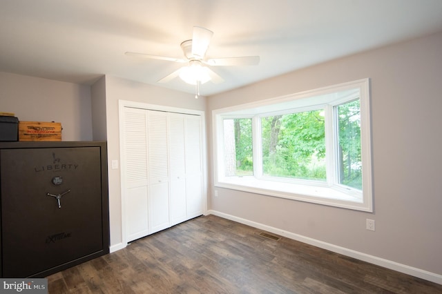 5470 Moose Lodge Rd, Cambridge, MD 21613 - unfurnished bedroom with dark wood-style floors, a closet, multiple windows, and a ceiling fan