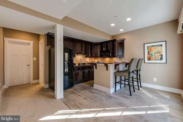 0006 Copperleaf Blvd, Hanover, MD 21076 - kitchen featuring freestanding refrigerator, a kitchen bar, a peninsula, dark brown cabinetry, and baseboards