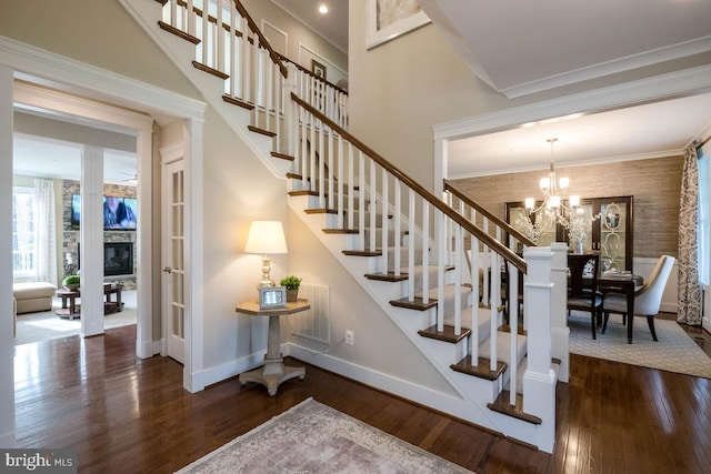 0006 Copperleaf Blvd, Hanover, MD 21076 - stairway featuring wood finished floors, baseboards, a chandelier, crown molding, and a stone fireplace