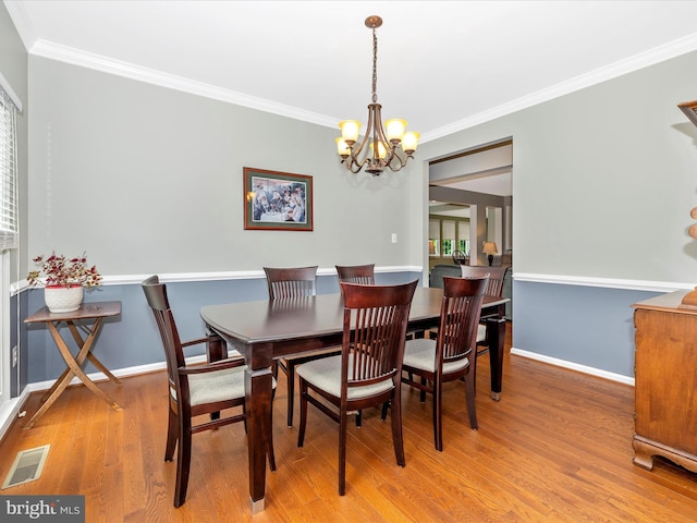 6470 Saddlebrook Ln, Frederick, MD 21701 - dining space featuring a chandelier, wood finished floors, crown molding, and baseboards