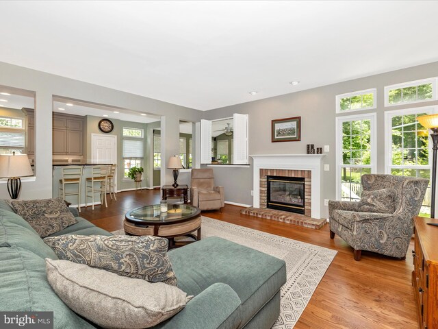 6470 Saddlebrook Ln, Frederick, MD 21701 - living room featuring plenty of natural light, wood finished floors, a brick fireplace, and recessed lighting