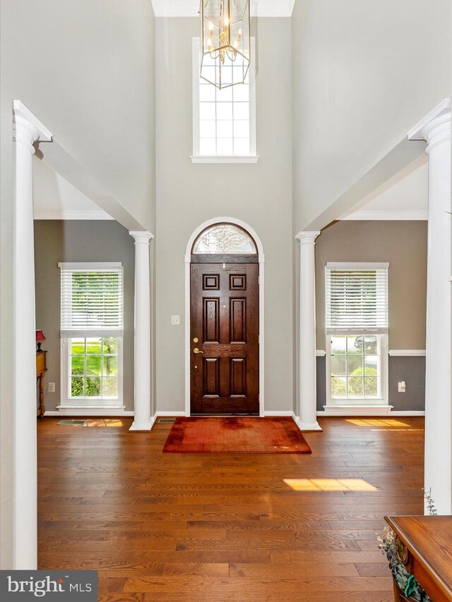 6470 Saddlebrook Ln, Frederick, MD 21701 - entrance foyer featuring decorative columns, a chandelier, wood finished floors, plenty of natural light, and a high ceiling