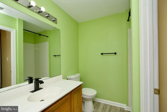 10305 Butternut Cir, Manassas, VA 20110 - bathroom featuring toilet, baseboards, vanity, wood finished floors, and a shower