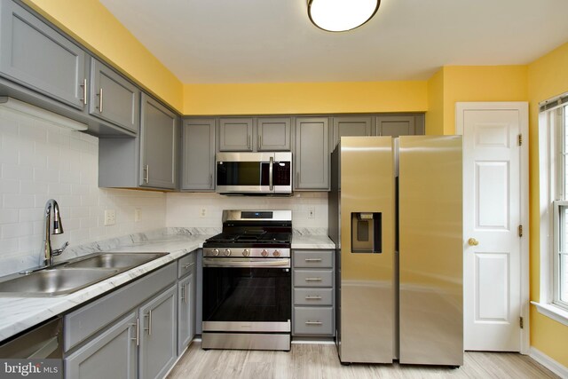 10305 Butternut Cir, Manassas, VA 20110 - kitchen featuring appliances with stainless steel finishes, gray cabinetry, a sink, and light wood-style flooring