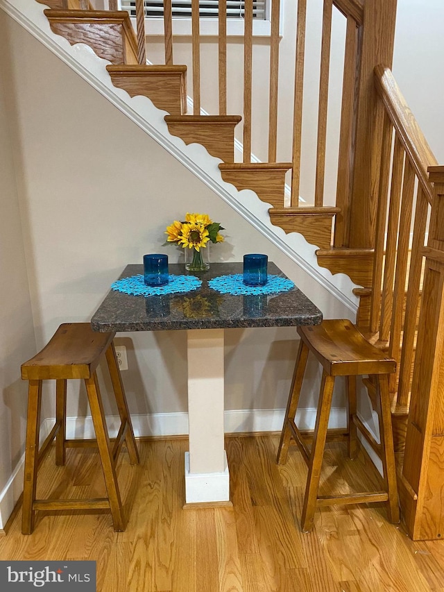 staircase featuring wood finished floors and baseboards