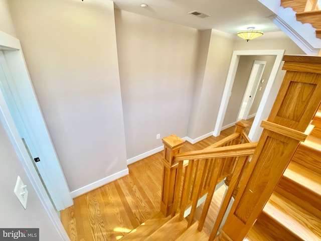 stairs with wood finished floors and baseboards