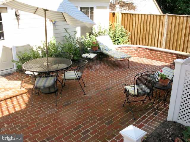 view of patio featuring outdoor dining space and fence