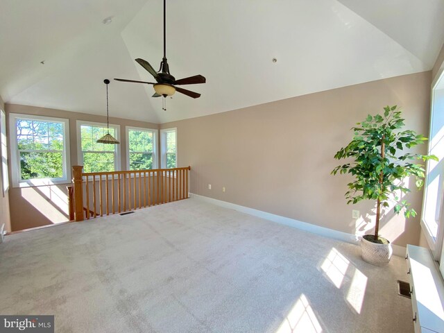 empty room with carpet, ceiling fan, high vaulted ceiling, and baseboards