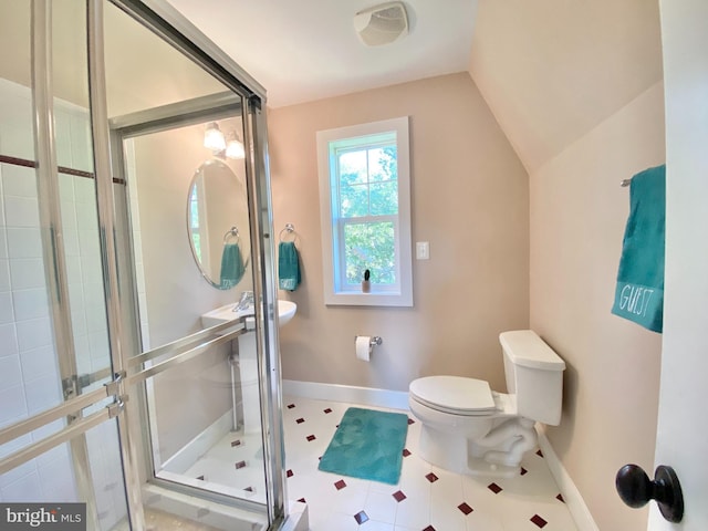 bathroom featuring a stall shower, lofted ceiling, baseboards, and toilet