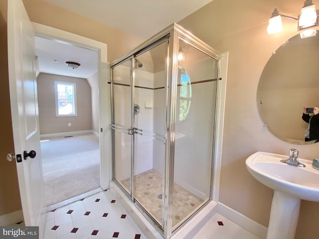 full bathroom featuring baseboards, a stall shower, vaulted ceiling, and a sink