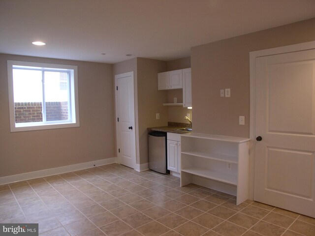 kitchen with stainless steel dishwasher, light tile patterned floors, open shelves, baseboards, and recessed lighting