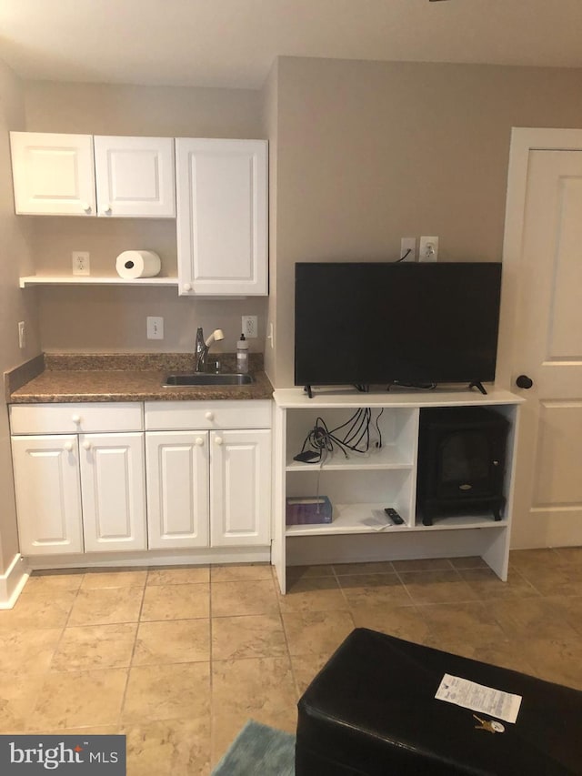 kitchen featuring a sink, open shelves, and white cabinetry