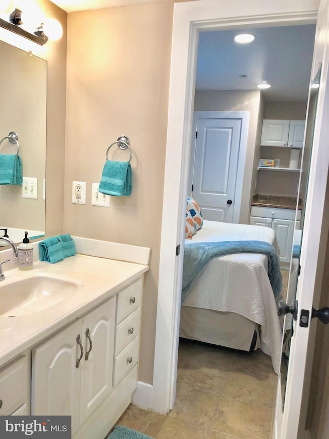 ensuite bathroom featuring vanity and baseboards