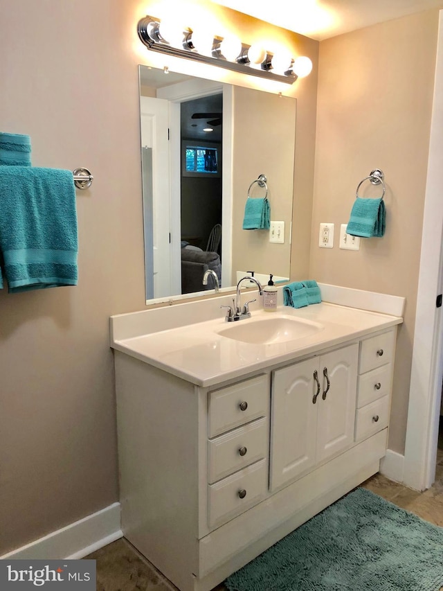 bathroom with baseboards, vanity, and ensuite bath