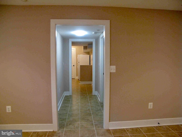 corridor with baseboards and tile patterned floors