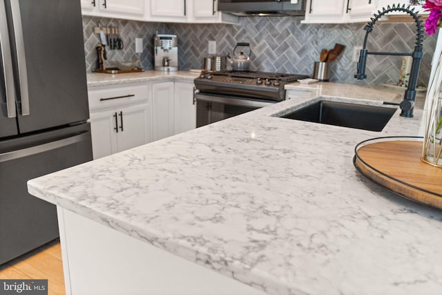 20387 Birchmere Ter, Ashburn, VA 20147 - kitchen with appliances with stainless steel finishes, tasteful backsplash, a sink, and white cabinets