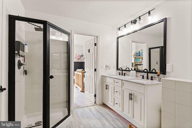 20387 Birchmere Ter, Ashburn, VA 20147 - bathroom with double vanity, a shower stall, and wood finished floors