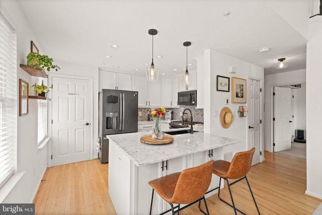 20387 Birchmere Ter, Ashburn, VA 20147 - kitchen with black microwave, stainless steel fridge with ice dispenser, a peninsula, white cabinets, and light wood-type flooring