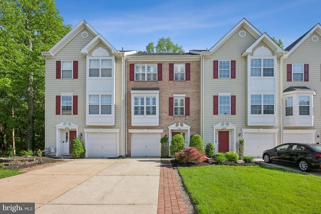 multi unit property with driveway, a garage, a front lawn, and brick siding
