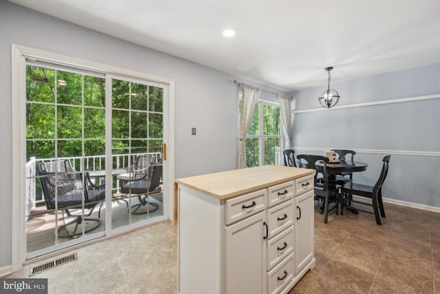 kitchen featuring white cabinets, pendant lighting, butcher block countertops, recessed lighting, and baseboards