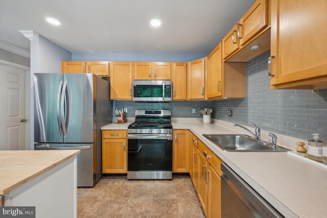 kitchen featuring stainless steel appliances, a sink, light countertops, crown molding, and tasteful backsplash