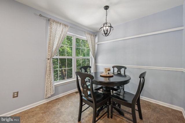 tiled dining space with a chandelier and baseboards