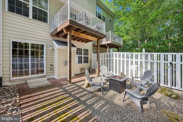 view of patio / terrace with a fire pit and a balcony