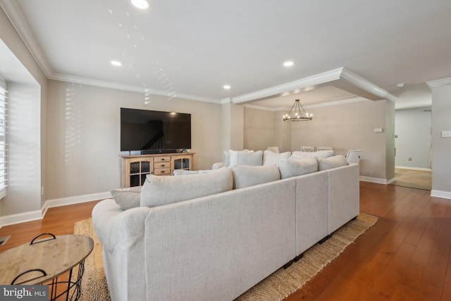 living room featuring ornamental molding, wood finished floors, baseboards, recessed lighting, and a chandelier