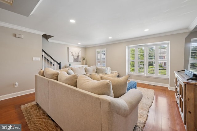 living area featuring wood finished floors, crown molding, baseboards, recessed lighting, and stairway