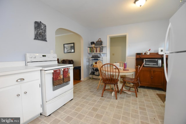 715 Susquehanna Cir, Newark, DE 19711 - kitchen featuring white appliances, arched walkways, light countertops, and white cabinets