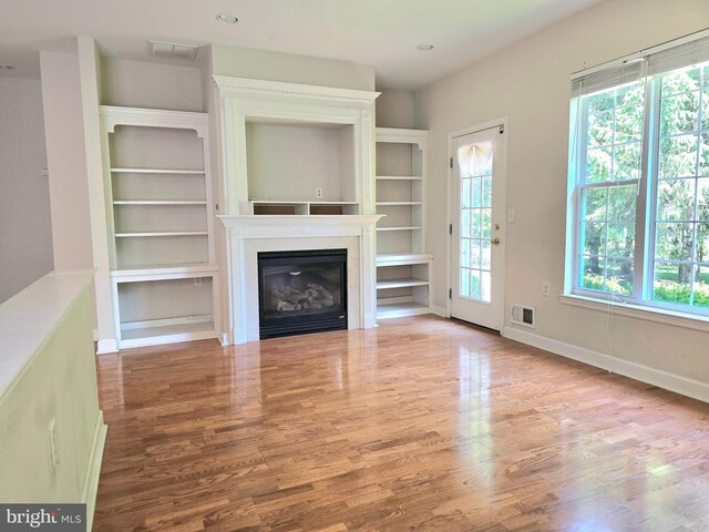 10 Honeyflower, Bordentown, NJ 08620 - unfurnished living room with plenty of natural light, wood finished floors, a glass covered fireplace, baseboards, and recessed lighting