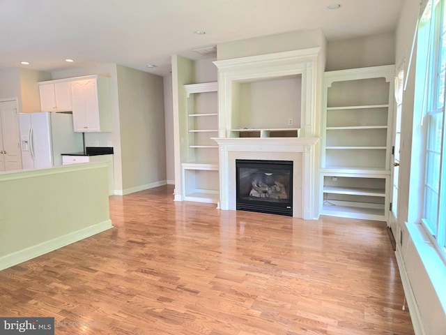10 Honeyflower, Bordentown, NJ 08620 - unfurnished living room featuring light wood-type flooring, baseboards, a glass covered fireplace, and recessed lighting