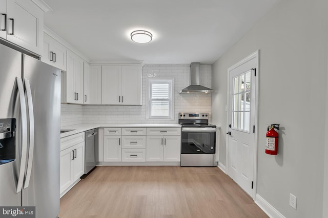 59 Jarvis St, Pemberton, NJ 08068 - kitchen featuring appliances with stainless steel finishes, wall chimney range hood, light wood-style floors, and plenty of natural light