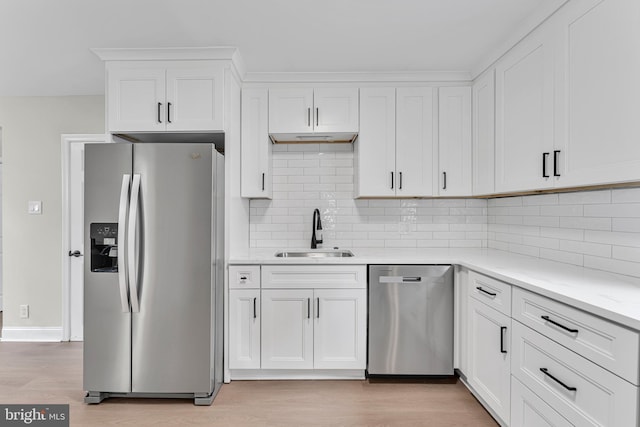59 Jarvis St, Pemberton, NJ 08068 - kitchen featuring appliances with stainless steel finishes, a sink, white cabinetry, decorative backsplash, and light wood finished floors