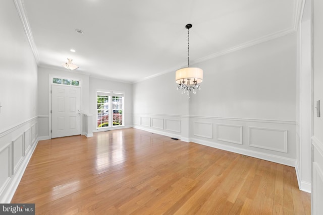 14 Osprey Ln, Bayville, NJ 08721 - unfurnished dining area with crown molding, a chandelier, a decorative wall, light wood-style floors, and wainscoting