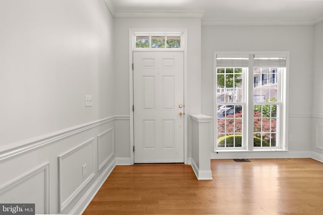 14 Osprey Ln, Bayville, NJ 08721 - entrance foyer featuring light wood finished floors, ornamental molding, a decorative wall, and wainscoting